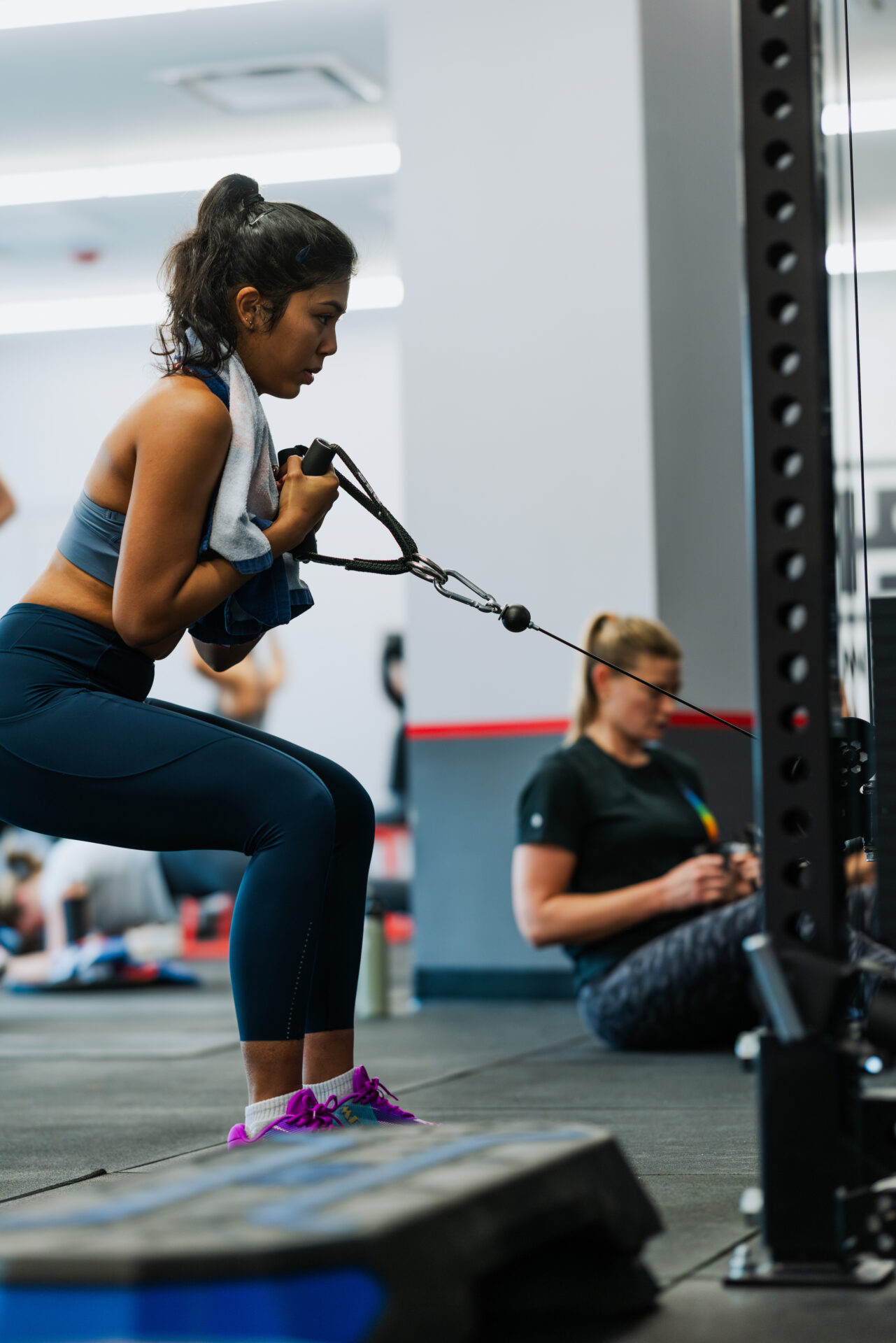 Female member completing a cable resistance exercise during an F45 workout