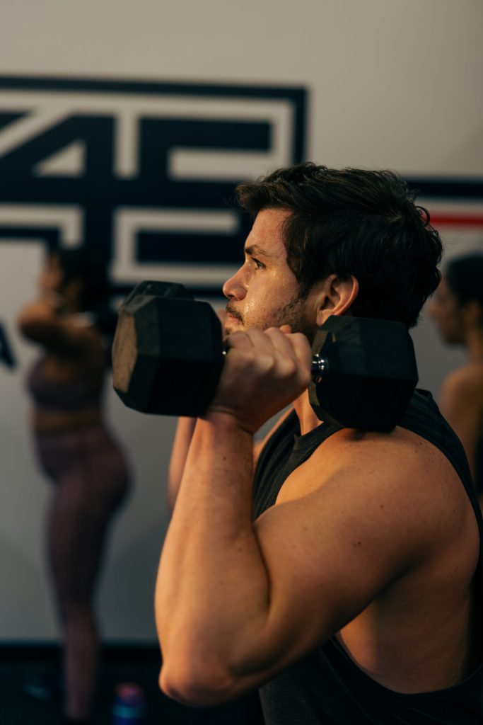 Man doing a shoulder press at an F45 workout