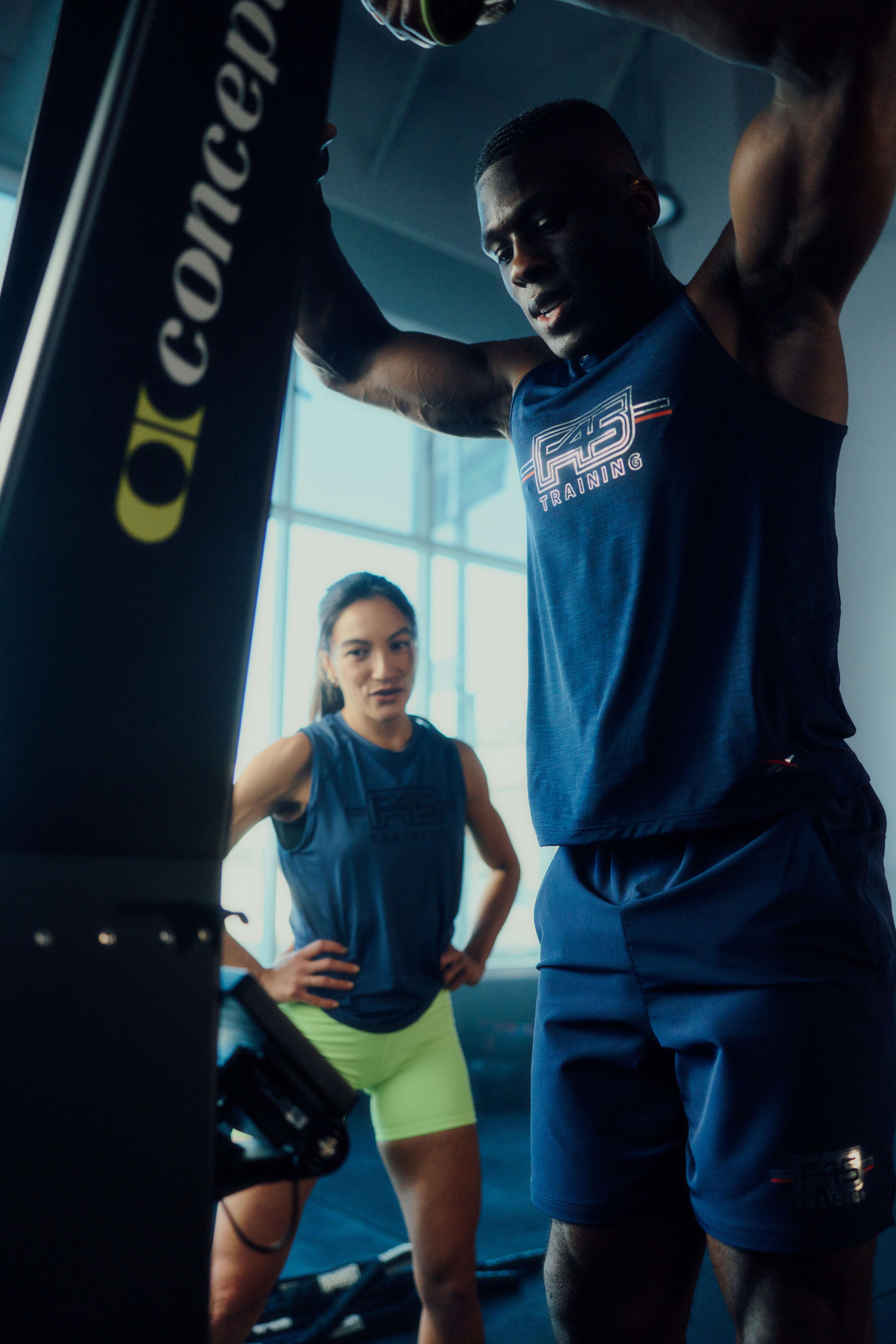 F45 coach Cristina Chan training a member on the SkiErg.